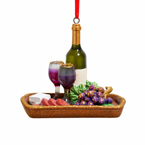 Miniature red wine tray ornament with wine bottle, two glasses, purple grapes, cheese slices on brown tray, hanging from red ribbon.