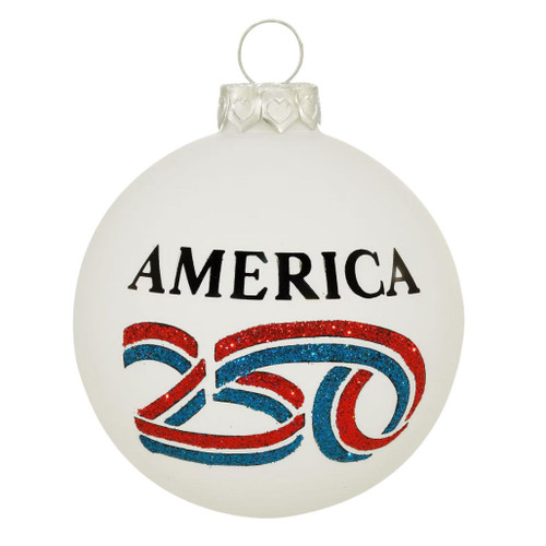 Round glass ornament with America 250™ logo, red, white, and blue ribbon motif, 3.5-inch size, sparkling finish, made in North Carolina, USA.