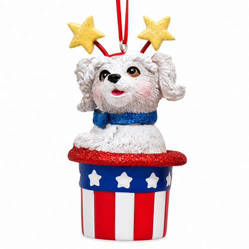 White dog ornament popping out of a patriotic red, white, and blue hat.
Resin dog Christmas ornament with glitter trim, white stars, and yellow star headband.
3-inch Kurt Adler America 250th hanging ornament with festive Americana design.