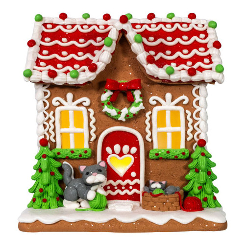 Lighted gingerbread house Christmas decoration with cat detail.
8 inch battery-operated LED gingerbread house tabletop décor.
Holiday gingerbread house display with warm illumination and playful cat.