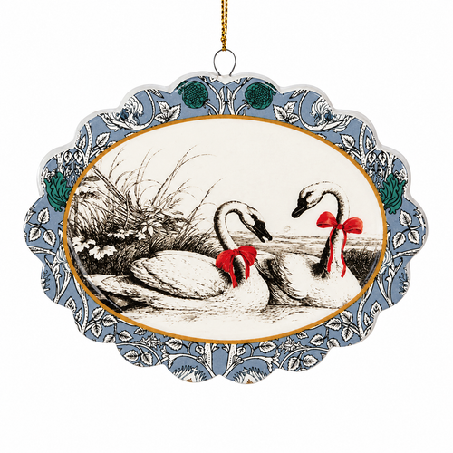 Scalloped swan ornament with two swans wearing red bows.
Dolomite Christmas ornament with blue floral border and gold oval trim.
3 1/8 x 4 1/4 inch swans on land ornament with hanging cord.