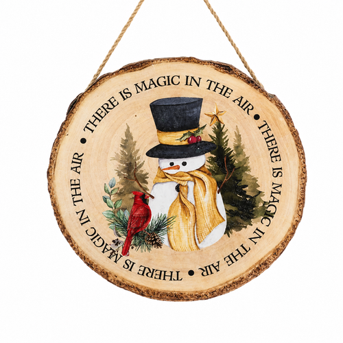 Wood slice ornament with snowman, cardinal, evergreens, and printed text.
Rustic MDF and jute Christmas ornament with “There is magic in the air” design.
Round winter ornament measuring 1.5 x 9 inches with jute hanger.