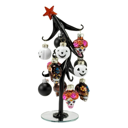 Glass black slanted Halloween tree with orange star topper.
Tree decorated with white pumpkin, black ball, and sugar skull ornaments.
8 inch glass tabletop tree with 12 hanging Halloween ornaments.