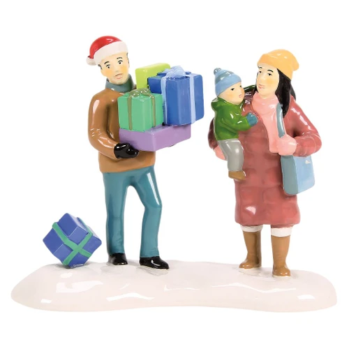 Department 56 Snow Village family accessory with parents, child, wrapped gifts, and snowy base.
Finally Home For The Holidays figurine showing a man carrying colorful presents beside a mother holding a child.
Rear view of Snow Village accessory with winter coats, Santa hat, shopping bag, and gift on the snow.