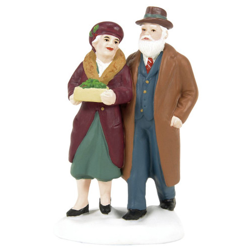 Department 56 Christmas In The City Not As Good As Yours accessory with elderly couple in winter coats.
Porcelain figurine of bundled couple walking together, with woman carrying a box of holiday treats.
Rear view of Christmas In The City couple accessory showing brown and burgundy coats on a snowy base.