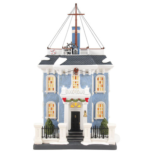 Department 56 Dickens Village Admiral Boom’s House lighted blue building with rooftop ship details.
Officially licensed Disney village house with mast rigging, ship’s wheel, cannons, and snowy roof.
Admiral Boom’s House shown with glowing windows and Admiral Boom accessory sold separately.