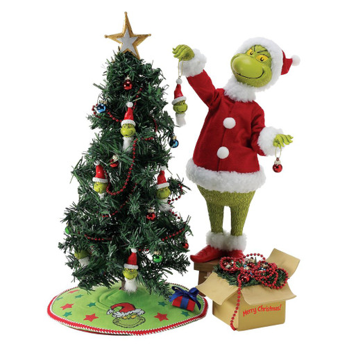 Department 56 Possible Dreams Everything Grinchy figurine with Grinch decorating a Christmas tree.
Grinch collectible in red Santa outfit beside a tree with Grinch ornaments, garland, star topper, and gift box.
Possible Dreams Everything Grinchy figurine measuring 16 inches high with PVC, polyester, resin, and Clothtique materials.