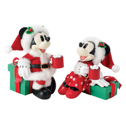 Department 56 Possible Dreams Cocoa Break figurine with Mickey and Minnie Mouse holding red cocoa mugs.
Mickey and Minnie collectible in Santa outfits beside green Christmas gift boxes with red ribbon.
Possible Dreams Cocoa Break figurine measuring 5.5 inches high with PVC, polyester, resin, and Clothtique materials.