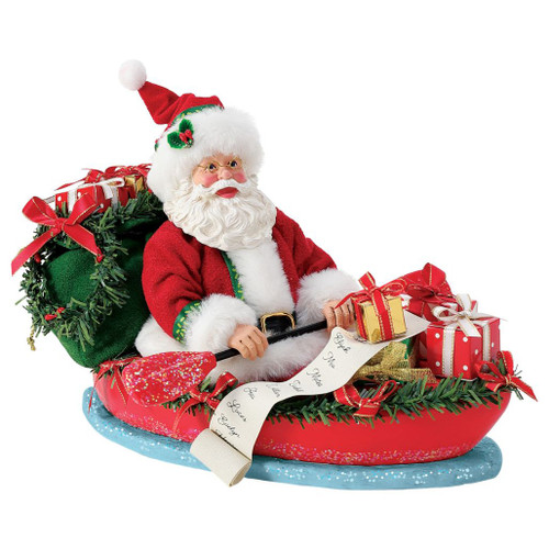 Department 56 Possible Dreams Going with the Flow Santa figurine in a red boat.
Santa sits with gifts, a green sack, garland trim, and a scrolling name list.
Going with the Flow Santa collectible measures 7 inches high and 11 inches long.