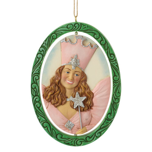 Jim Shore Wizard of Oz rotating ornament featuring Glinda the Good Witch on one side and the Wicked Witch of the West on the reverse.
Double-sided Heartwood Creek ornament with hand-painted folk-art details and decorative green frame.
Stone powder and resin Wizard of Oz hanging ornament with rotating character portraits.