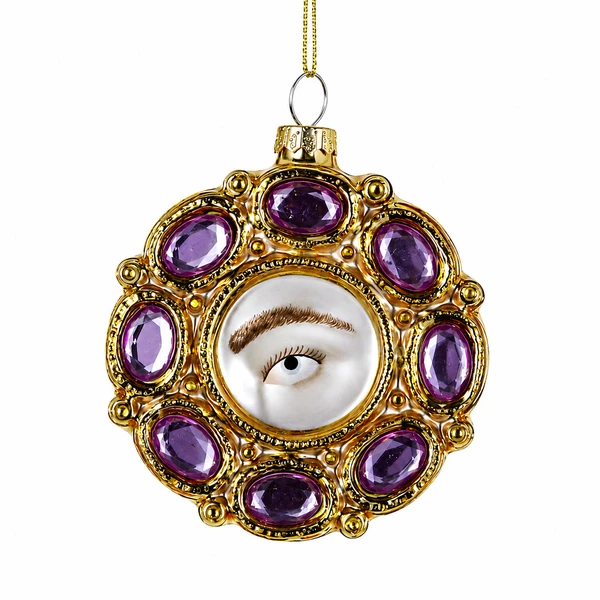 Jeweled Lovers Eye glass ornament with central painted eye and gold trim.
Round glass ornament with purple jewel-like accents and ornate frame.
Lovers Eye glass ornament measuring 2.75 x .75 x 3 inches.