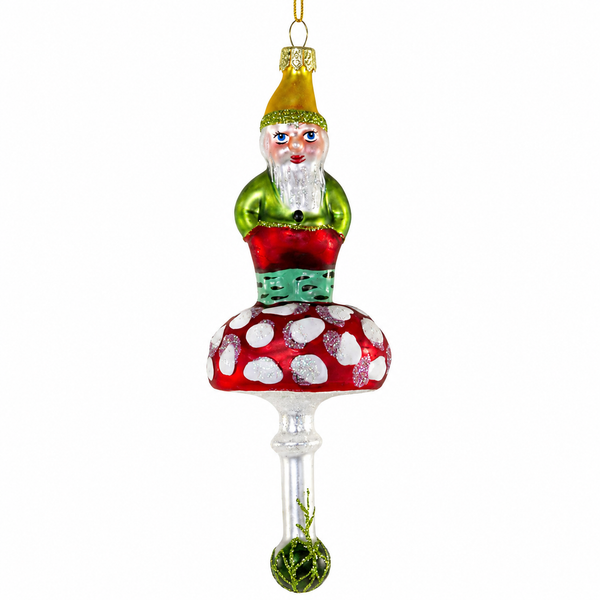 Forest gnome glass Christmas ornament sitting on a red-and-white spotted mushroom.
Woodland gnome ornament with green outfit, golden hat, glitter accents, and hanging cord.
2 x 2 x 6 inch glass gnome ornament for Christmas tree or woodland holiday décor.