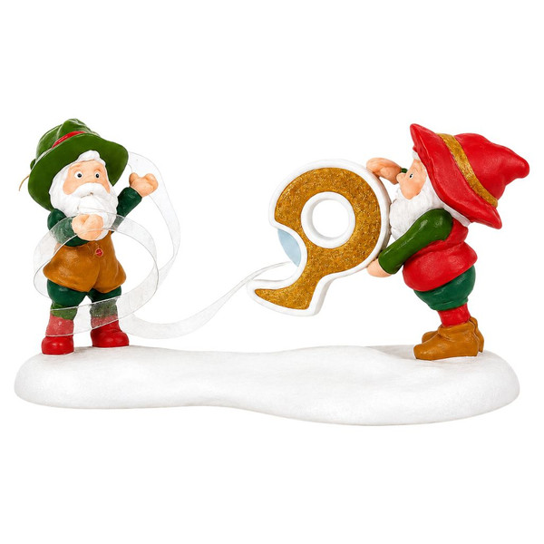 Department 56 Say When... North Pole Village accessory featuring elves tangled in holiday ribbon.

Hand-painted porcelain village figurine showing a festive Christmas gift-wrapping scene.

Small North Pole Village accessory measuring approximately 3 inches tall.