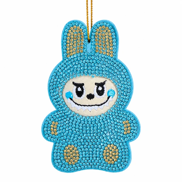 Blue bedazzled monster ornament with sparkling gem-covered body and bunny-style ears.
Whimsical embroidered face with black eyes, smile, and blue cheeks.
3.5-inch Kurt Adler ornament made from fabric mâché, plastic, and polyester.