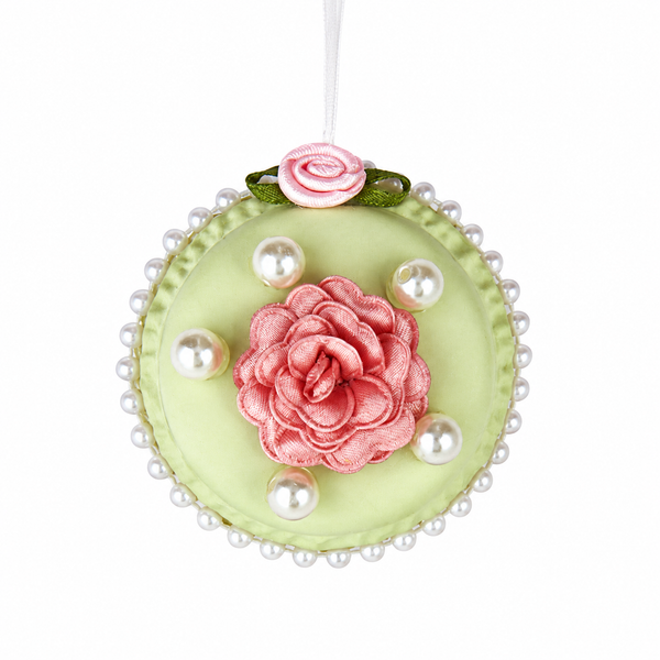 Green round macaron ornament with a silk tea rose center, faux pearls around and on top, hanging from white ribbon.
