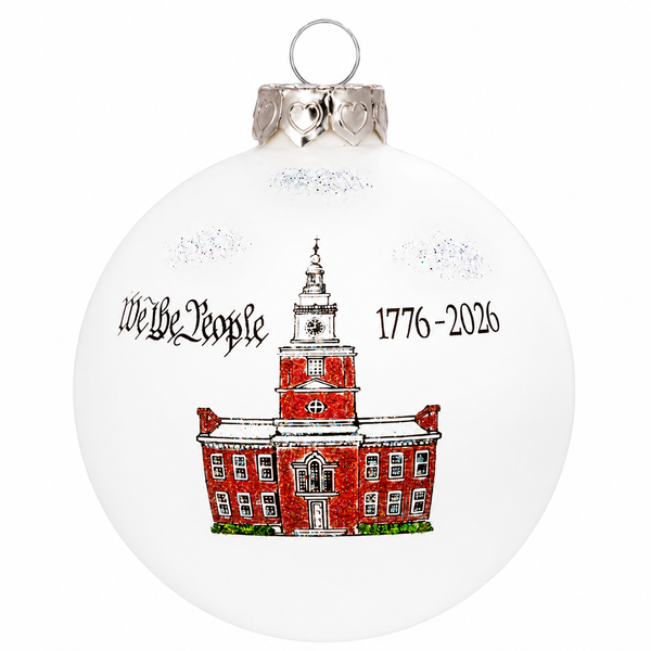 Round glass ornament featuring Independence Hall in red with sparkling accents, “We the People” text, 3.5-inch size, made in North Carolina, USA.