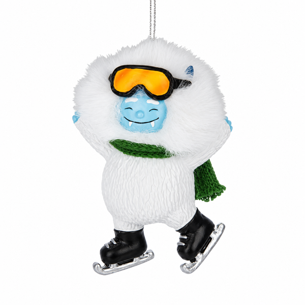 Yeti ornament with green scarf, orange goggles, and black ice skates.
Resin Christmas ornament featuring white furry-look yeti and blue face.
Winter sports ornament measuring 3.25 inches with hanging chain.