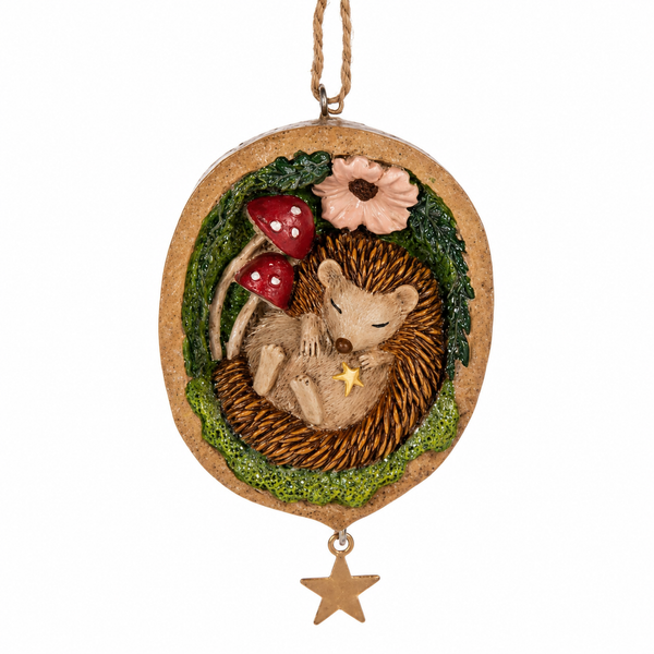 Hedgehog ornament nestled inside a walnut shell with leafy greenery.
Resin Christmas ornament with red mushrooms, flower detail, and hanging star.
Woodland hedgehog ornament measuring 2 1/8 x 3 1/4 inches.