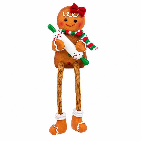 Gingerbread baker shelfsitter holding a rolling pin with dangling legs.
Resin gingerbread character with red bow, striped scarf, and festive details.
7.5-inch gingerbread Christmas shelf decoration with bakery theme.