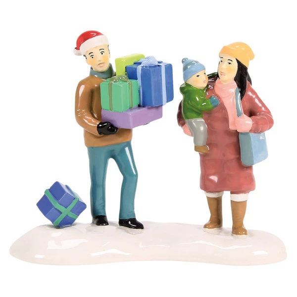 Department 56 Snow Village family accessory with parents, child, wrapped gifts, and snowy base.
Finally Home For The Holidays figurine showing a man carrying colorful presents beside a mother holding a child.
Rear view of Snow Village accessory with winter coats, Santa hat, shopping bag, and gift on the snow.