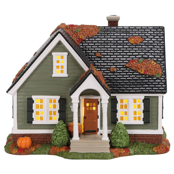 Department 56 November 13th Again House with green siding, black roof, glowing windows, porch, and pumpkins.
Snow Village Halloween lighted house with autumn leaves on the roof, white trim, shrubs, and front steps.
USB-powered polyresin and ceramic village house with fall leaf details and included adapter.