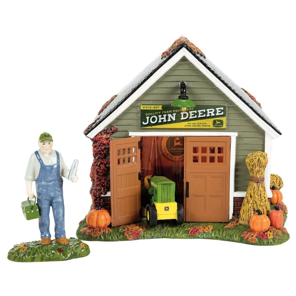 Department 56 John Deere Still Running! set with farm equipment shop, mower, pumpkins, and farmer figure.
Snow Village Halloween lighted John Deere-themed building with open garage doors, hay bundle, and fall leaves.
Officially licensed Deere & Company village set with USB power, adapter, and separate farmer accessory.