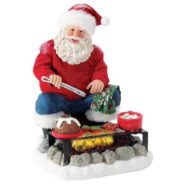 Department 56 Possible Dreams Grilled to Perfection Santa figurine with Santa seated by a snowy grill.
Santa holds tongs beside a lit grill with fruitcake, tree-shaped skewers, and a red mug.
Grilled to Perfection Santa measures 9 inches high and includes LED lighting.