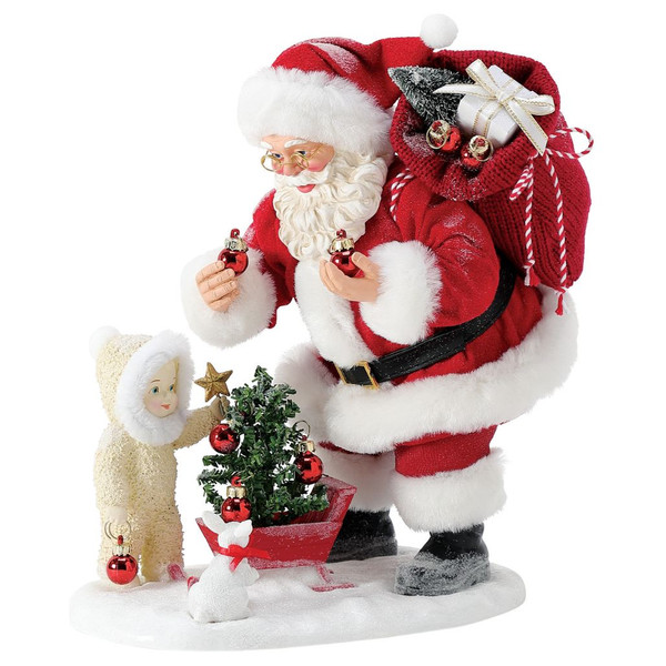 Santa decorating a miniature Christmas tree with a child while holding red ornaments and carrying a gift sack.
Possible Dreams Adding Sparkle Santa figurine with Clothtique fabric details and snowy base.
10.5-inch hand-painted Christmas collectible featuring a festive tree decorating scene.