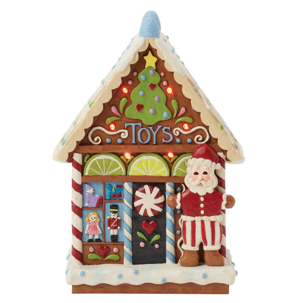 Jim Shore LED gingerbread toy shop figurine with Santa, candy details, and illuminated Christmas tree above the entrance.
Hand-painted Heartwood Creek stone resin gingerbread toy shop featuring glowing LED lights, toy window display, and festive candy accents.
Decorative Christmas LED village building with Santa, peppermint door, colorful icing roof, and battery-operated illumination.