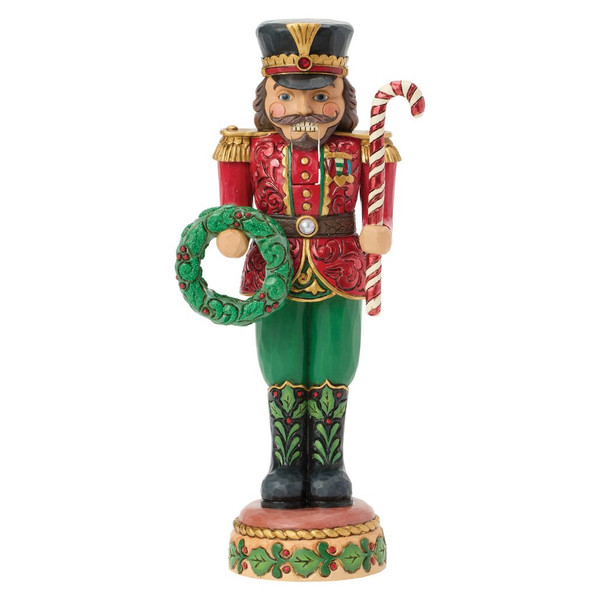 Jim Shore Festive Duty toy soldier nutcracker holding a striped candy cane and green holiday wreath.
Hand-painted stone resin nutcracker in a red and green military uniform with gold trim and movable mouth lever.
Heartwood Creek decorative toy soldier nutcracker featuring folk-art rosemaling details and festive Christmas accents.