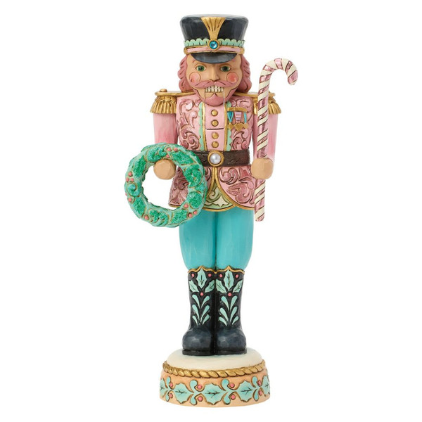 Jim Shore Pastel Patrol toy soldier nutcracker holding a striped candy cane and green holiday wreath.
Hand-painted stone resin pastel nutcracker in pink, blue, mint green, and gold with a movable mouth lever.
Heartwood Creek decorative Christmas soldier figurine featuring folk-art rosemaling and pastel holiday colors.