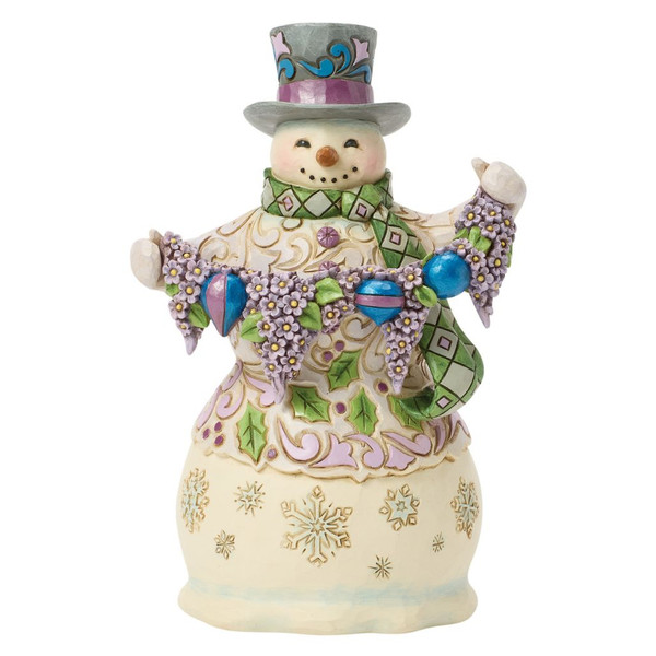 Jim Shore Regal Winter snowman figurine wearing a lavender-accented top hat and green patterned scarf.
Hand-painted stone resin snowman holding a purple floral garland with colorful ornaments and folk-art rosemaling.
Heartwood Creek Regal Winter collectible snowman featuring pastel winter colors and detailed snowflake accents.