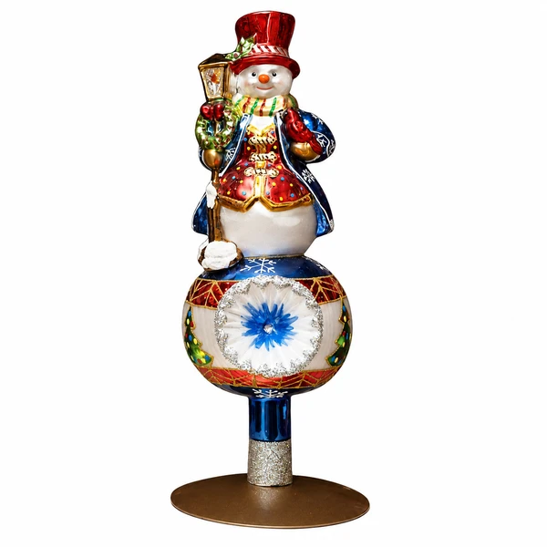 Huras Family handblown glass snowman Christmas tree topper on a white background.

Hand-painted snowman tree topper with red top hat, blue coat, lantern, and colorful gold-accented details.

Polish glass snowman tree topper featuring red, blue, white, and gold hand-painted decoration.