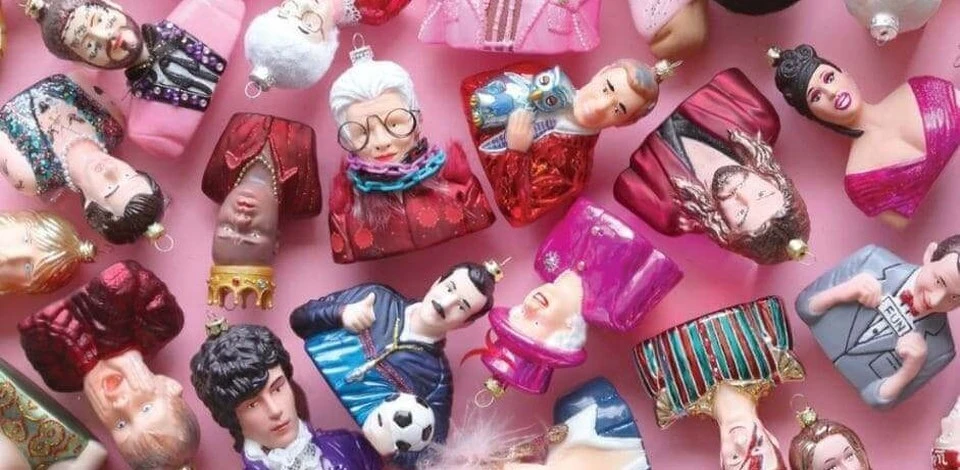 Cody Foster glass celebrity ornaments on a pink background