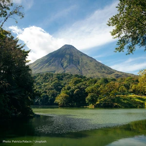 Arenal Volcano rising above rainforest, reflected in a calm lake in northern Costa Rica.