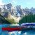 Red canoes moored on the turquoise water of Moraine Lake beneath the Valley of the Ten Peaks, Banff National Park, Canada