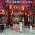 Giant incense coils hanging from the ceiling of a Hanoi temple, with a visitor standing before the red and gold altar