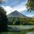 Arenal Volcano rising above rainforest, reflected in a calm lake in northern Costa Rica.