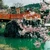 Cherry blossom framing a vermilion bridge and a small shrine above a green pond in Japan in spring.