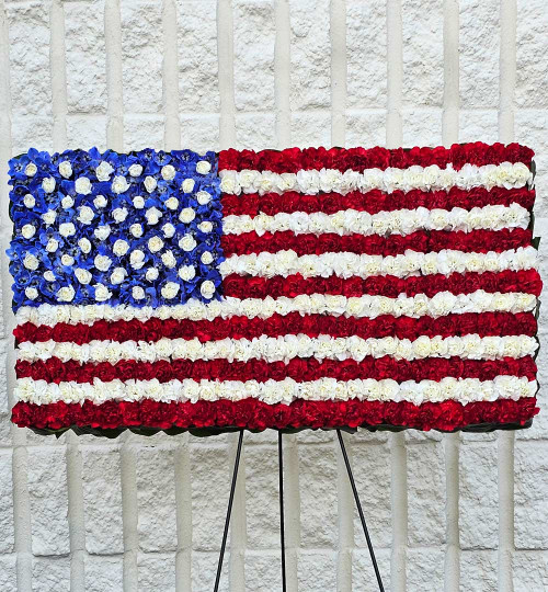 American Flag patriotic funeral standing spray handcrafted with red and white carnations and blue delphinium by Nancy's Floral in Gresham Oregon