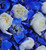 Close-up of American Flag funeral standing spray featuring white miniature carnation stars surrounded by royal blue delphinium flowers, handcrafted by Nancy's Floral.