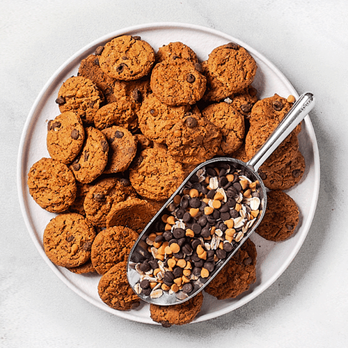 Cookie's cookie on plate with spoonful of butterscotch and chocolate chips Cookie's cookie on plate with spoonful of butterscotch and chocolate chips