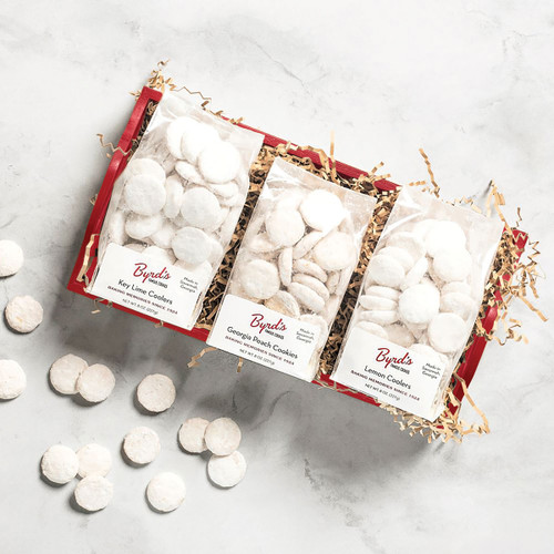 Red tray with key lime coolers, lemon coolers, and georgia peach cookie bags and scattered cookies.