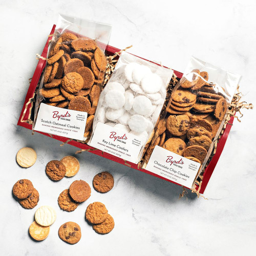 Red gray tray with scotch oatmeal, chocolate chip, and key lime cookie bags, cookies scattered.