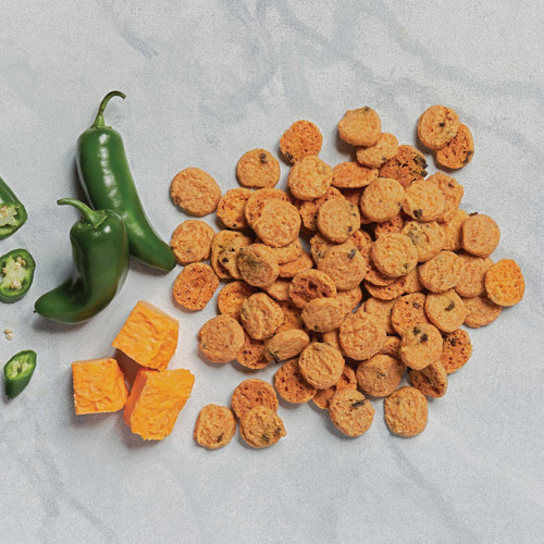 Jalapeno cheddar biscuits scattered with two whole jalapenos  and 3 sliced jalapeno pies overhead Jalapeno cheddar biscuits scattered with two whole jalapenos  and 3 sliced jalapeno pies overhead