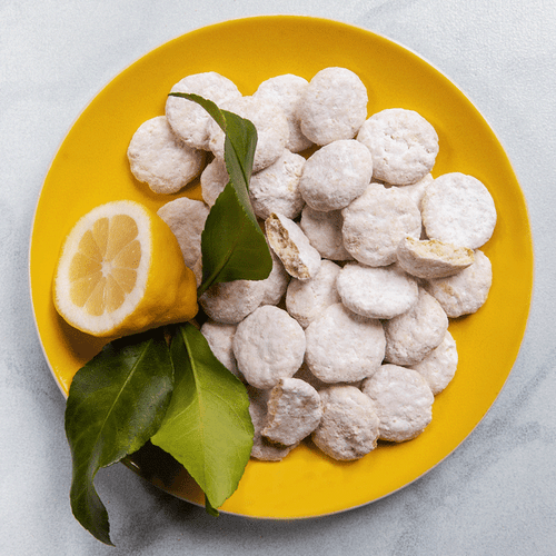 Lemon cooler cookies on yellow plate with sliced lemon and leaves Lemon cooler cookies on yellow plate with sliced lemon and leaves