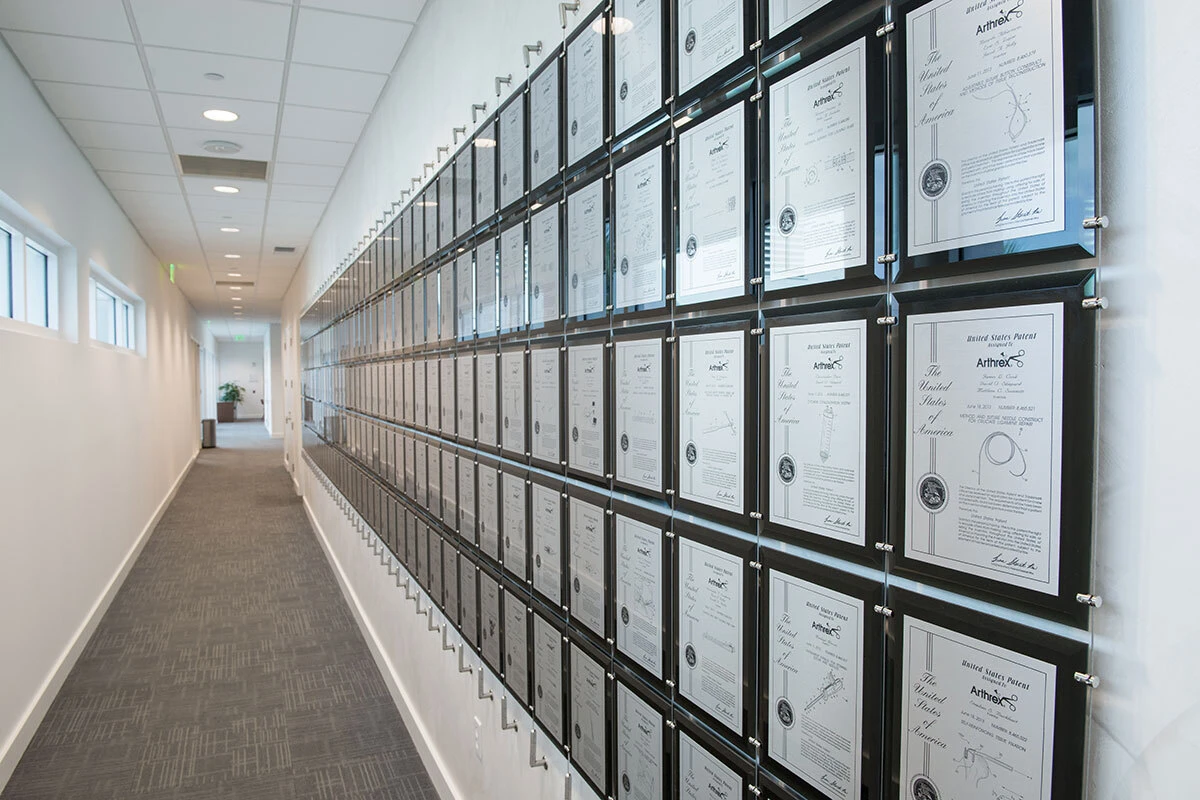 Black acrylic patent awards displayed on a cable tension system
