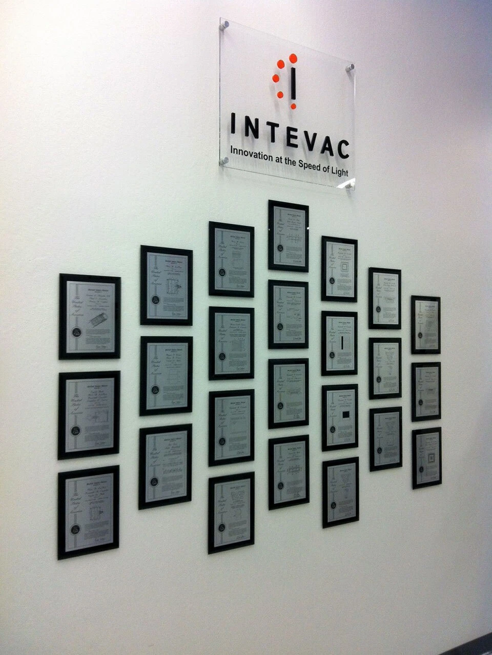 Black glass patent awards arranged beneath a corporate logo