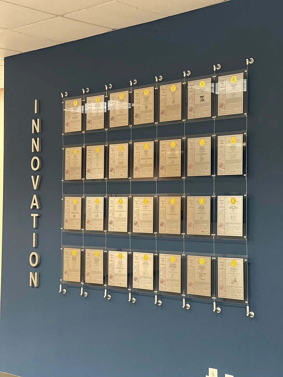 Clear acrylic patent awards installed on a cable tension system