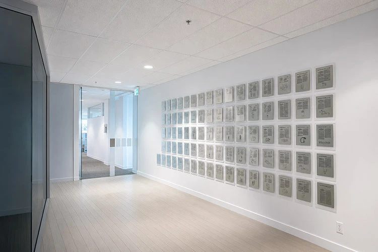 A corporate hallway featuring a large wall display of framed patents